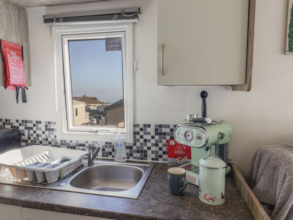 A kitchen with a sink and coffee machine at Beech Walk 3 Sandy Bay, Exmouth