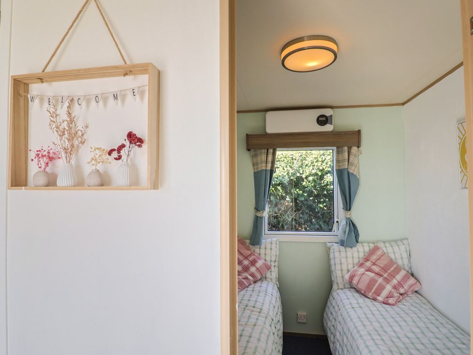 A bedroom with twin beds and a window at Beech Walk 3 Sandy Bay Exmouth