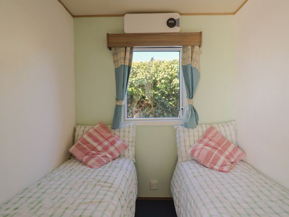 A bedroom with two single beds and a window at Beech Walk 3 Sandy Bay, Exmouth