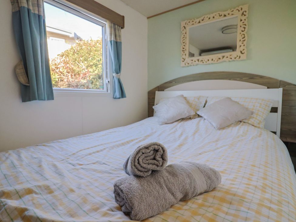 A bedroom with a bed and window at Beech Walk 3 Sandy Bay, Exmouth