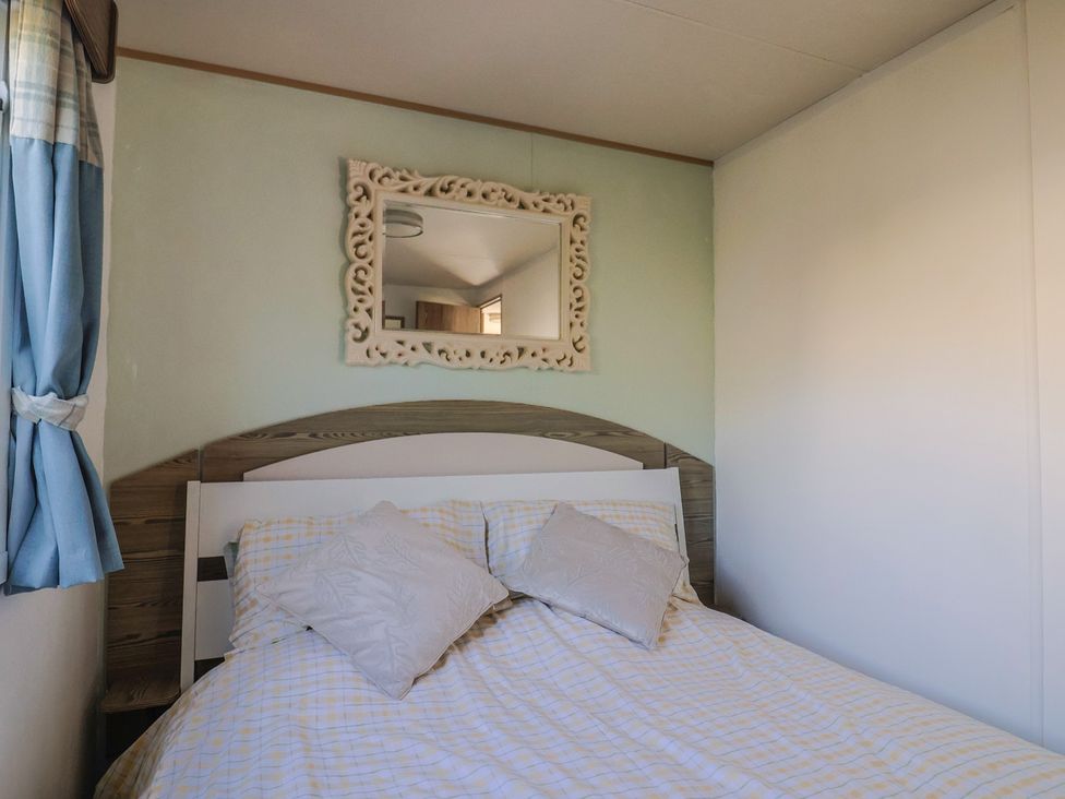 A bedroom with a bed and mirror at Beech Walk 3 in Sandy Bay, Exmouth