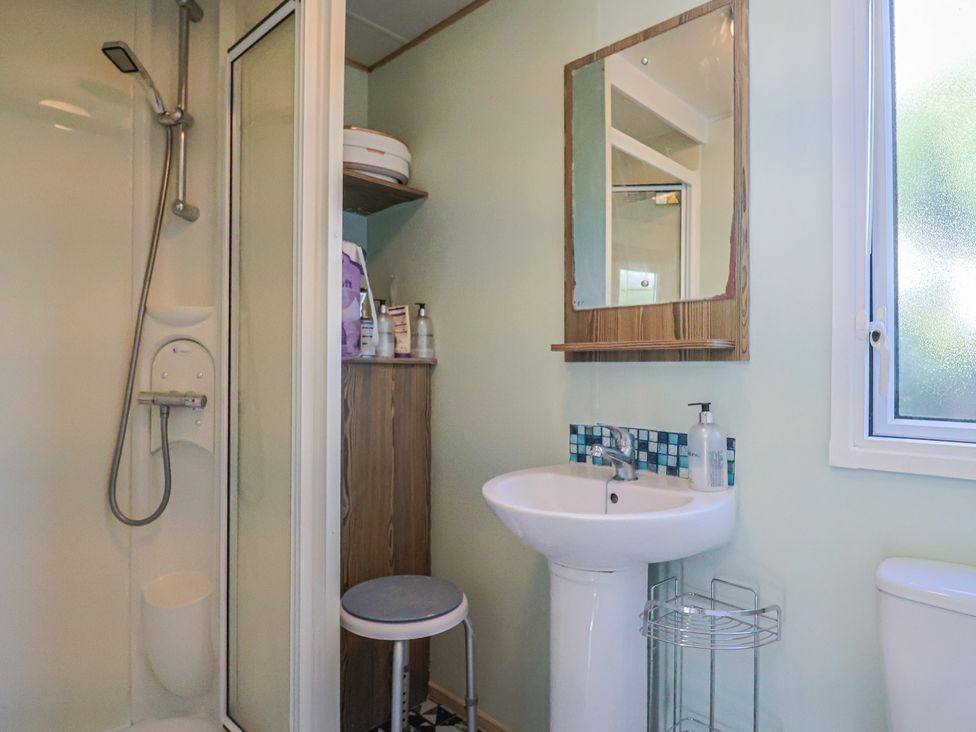 A bathroom with a shower, sink, and mirror at Beech Walk 3 Sandy Bay, Exmouth