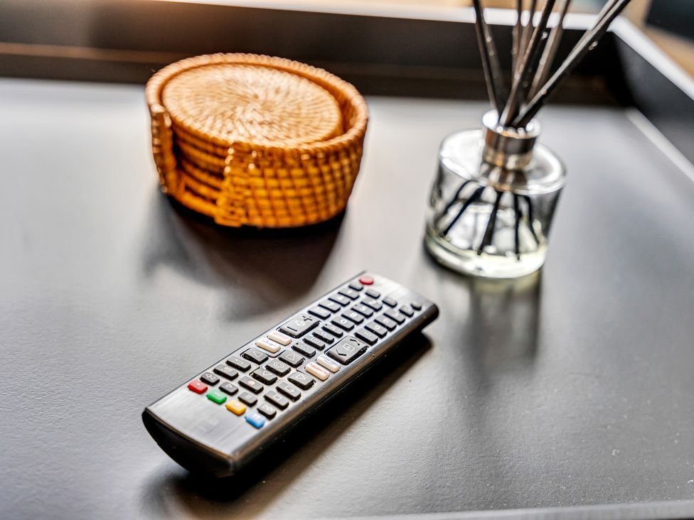 A living room with a remote control, woven basket, and aroma diffuser at Stoke Townhouse in Stoke-on-Trent
