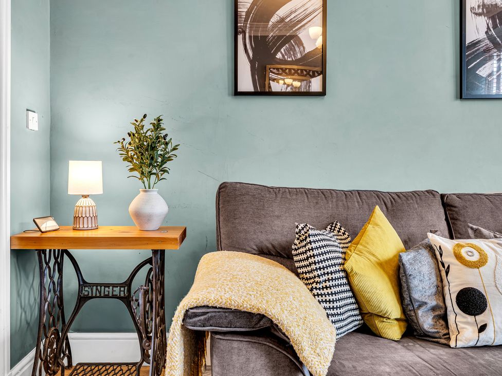 A living room with a sofa and side table at Stoke Townhouse in Stoke-on-Trent
