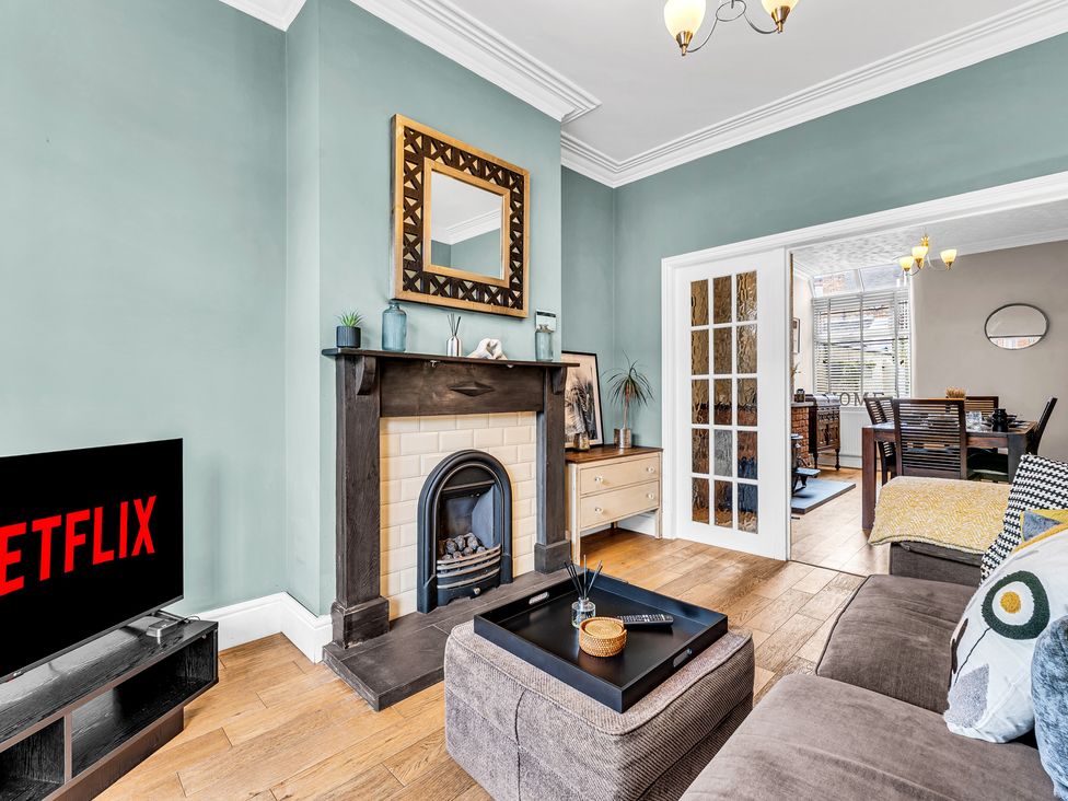 A living room with a television and fireplace at Stoke Townhouse in Stoke-on-Trent