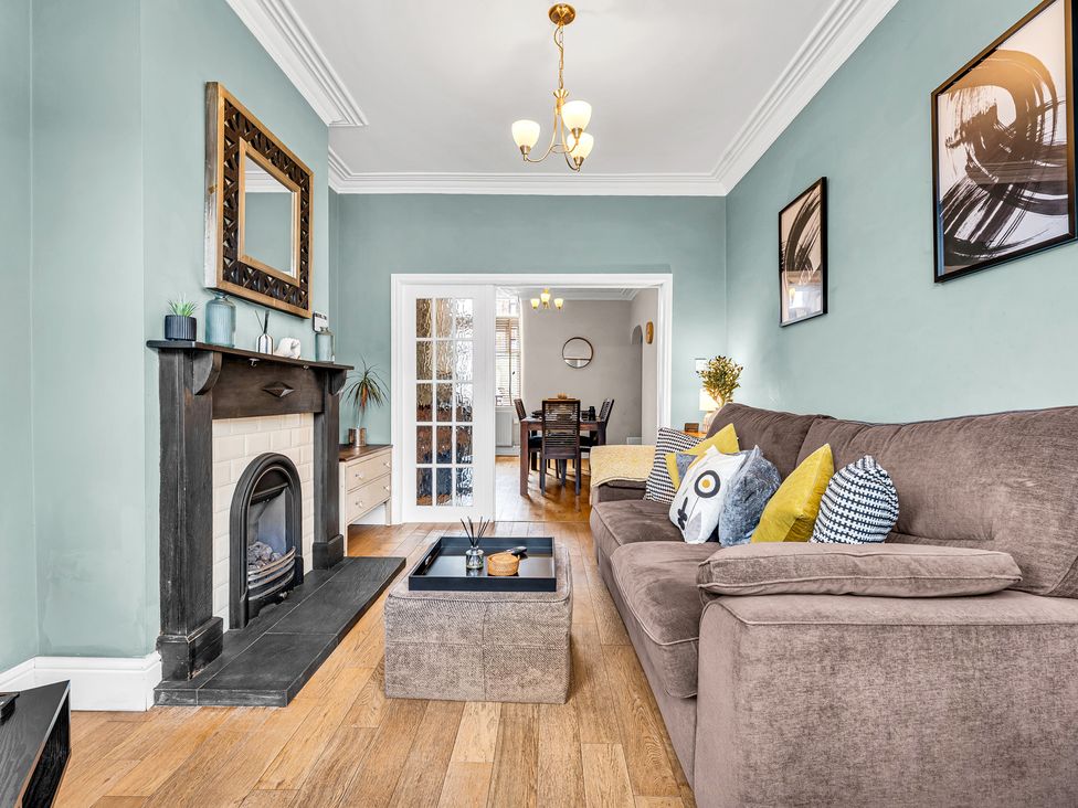 A living room with a fireplace and sofa at Stoke Townhouse in Stoke-on-Trent