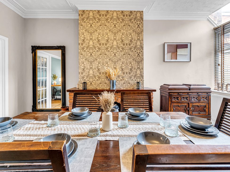 A dining room with a table set and decorative items at Stoke Townhouse in Stoke-on-Trent
