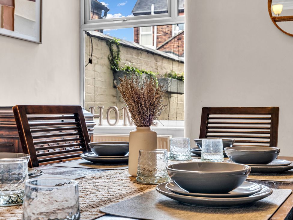 A dining room with a table set for a meal at Stoke Townhouse in Stoke-on-Trent