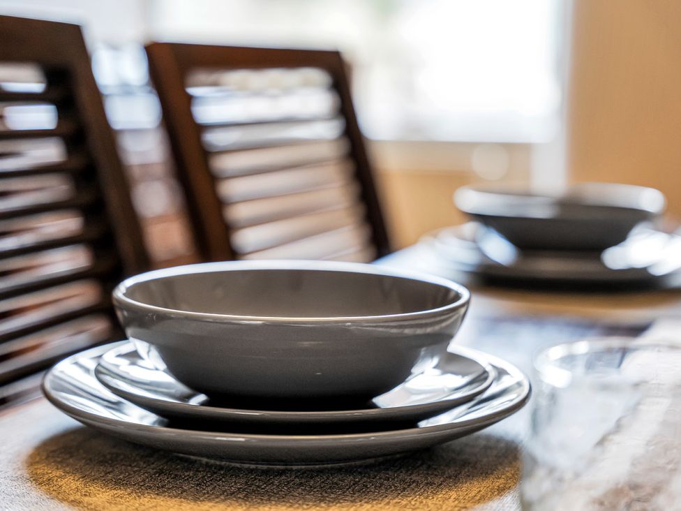 A dining table set with plates and bowls at Stoke Townhouse in Stoke-on-Trent