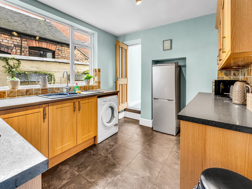 A kitchen with appliances and a door to the outside at Stoke Townhouse in Stoke-on-Trent