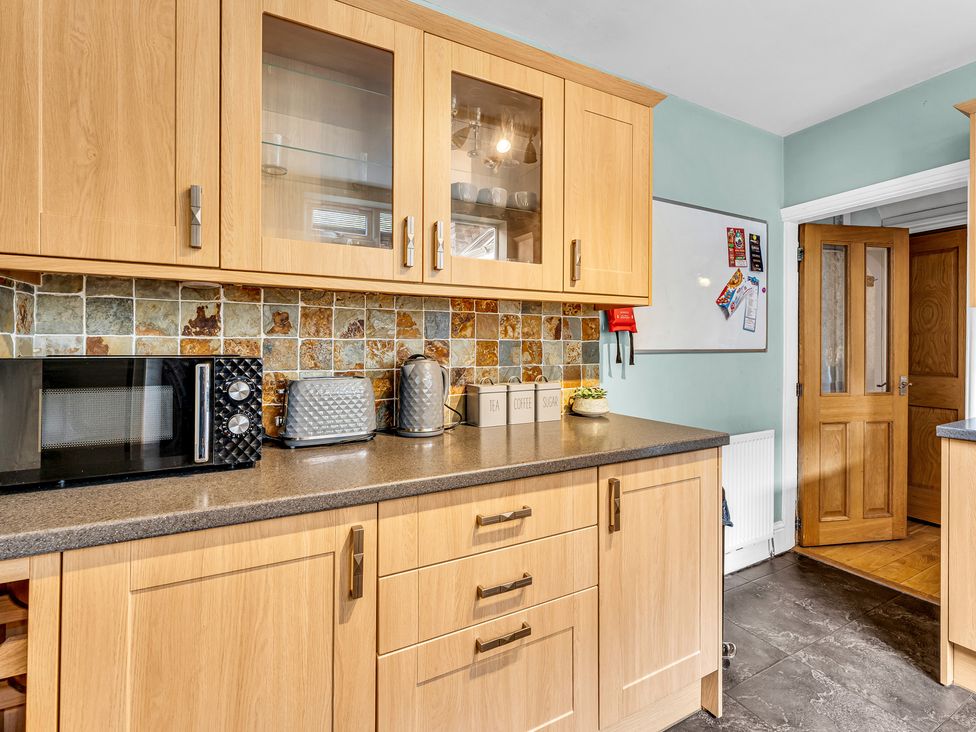A kitchen with appliances and storage cabinets at Stoke Townhouse in Stoke-on-Trent