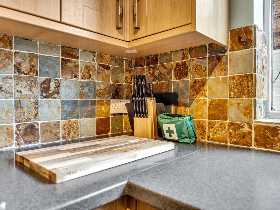 A kitchen counter with a cutting board and knife block at Stoke Townhouse in Stoke-on-Trent