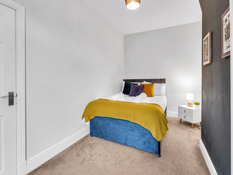 A bedroom with a bed and side table at Stoke Townhouse in Stoke-on-Trent