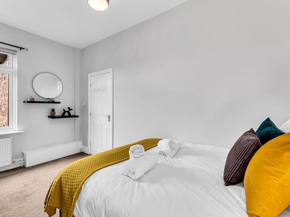 A bedroom with a bed and a shelf at Stoke Townhouse in Stoke-on-Trent