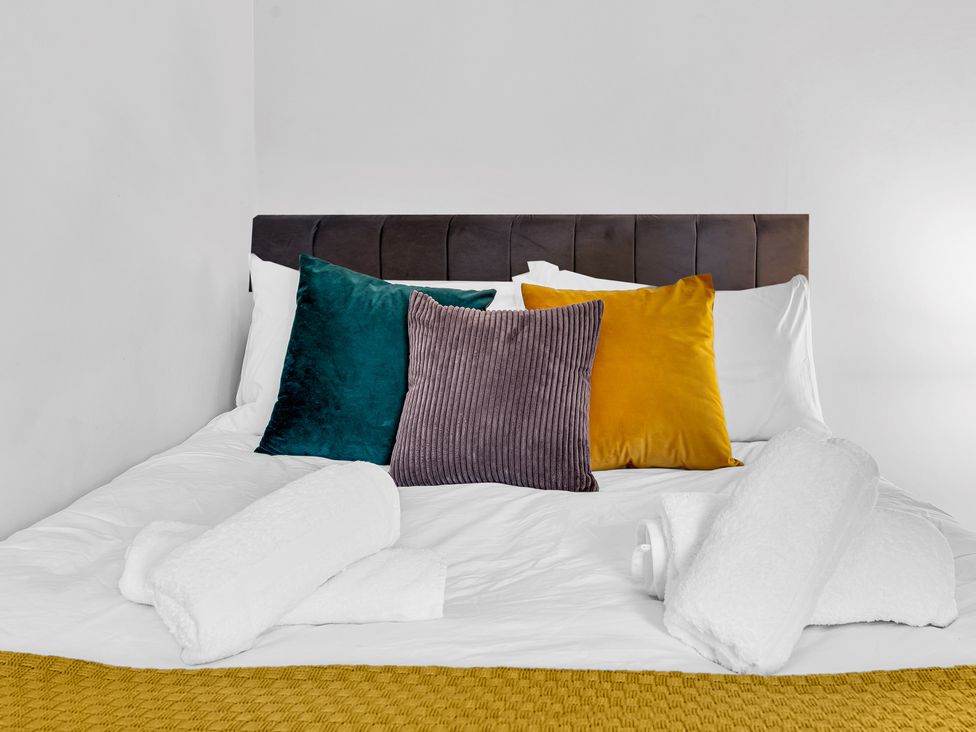 A bed with pillows and towels at Stoke Townhouse in Stoke-on-Trent