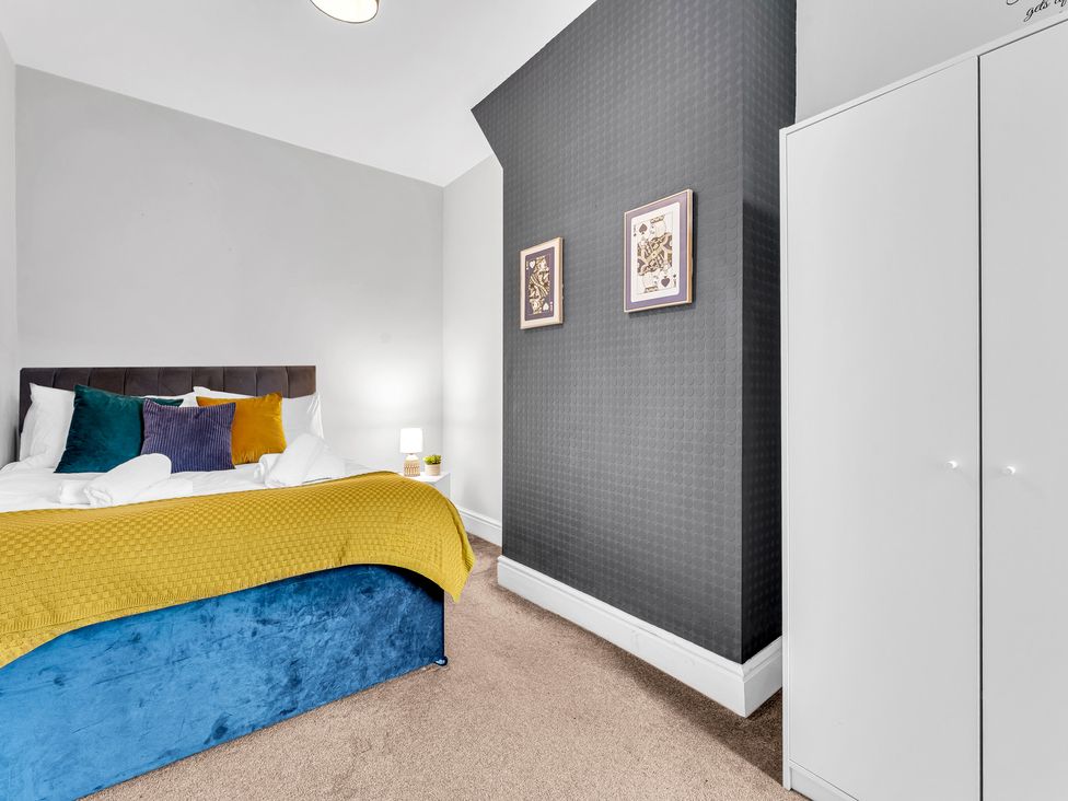 A bedroom with a bed and wardrobe at Stoke Townhouse in Stoke-on-Trent