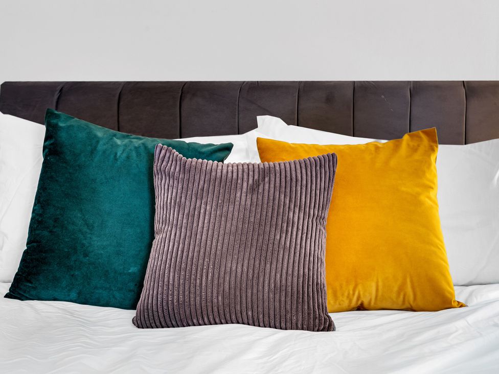 Three pillows on a bed at Stoke Townhouse in Stoke-on-Trent