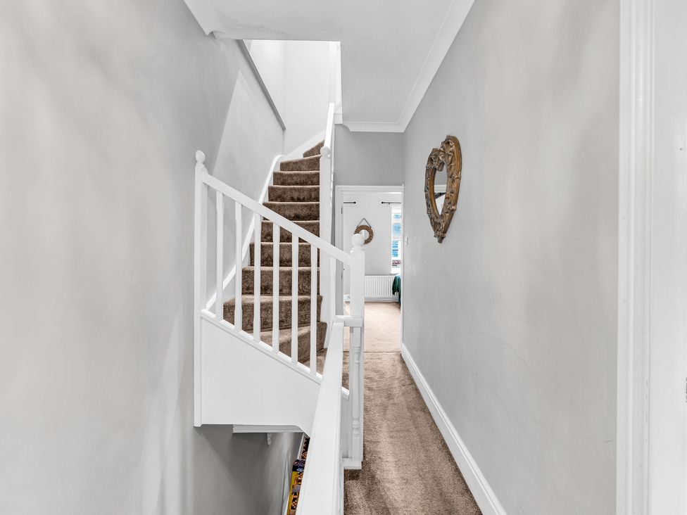 A hallway with a staircase and a mirror at Stoke Townhouse in Stoke-on-Trent
