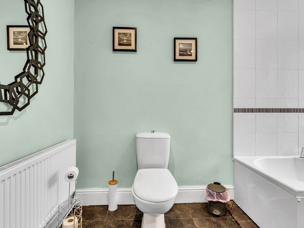 A bathroom with a toilet and bathtub at Stoke Townhouse in Stoke-on-Trent