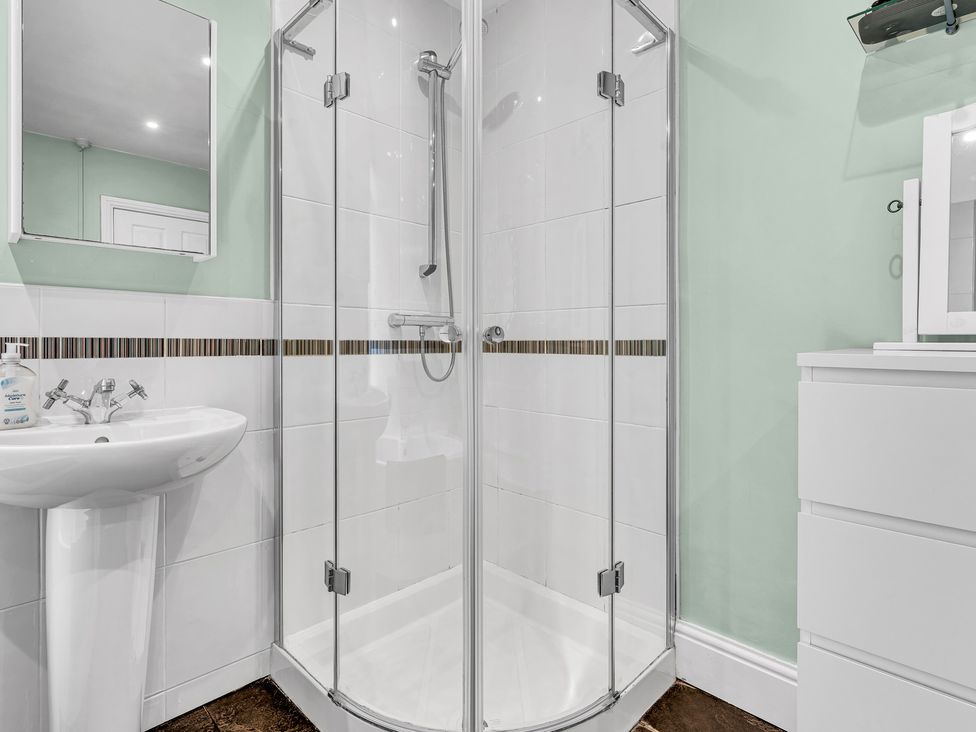 A bathroom with a shower and basin at Stoke Townhouse in Stoke-on-Trent