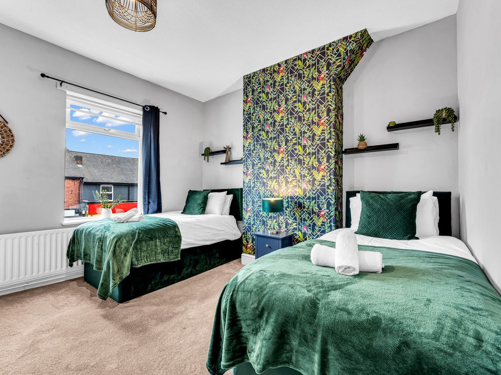 A bedroom with two beds and a window at Stoke Townhouse in Stoke-on-Trent