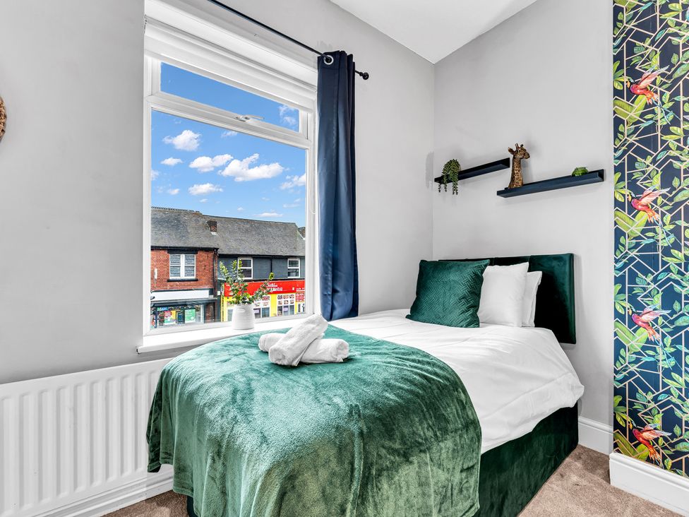 A bedroom with a bed and window views at Stoke Townhouse in Stoke-on-Trent