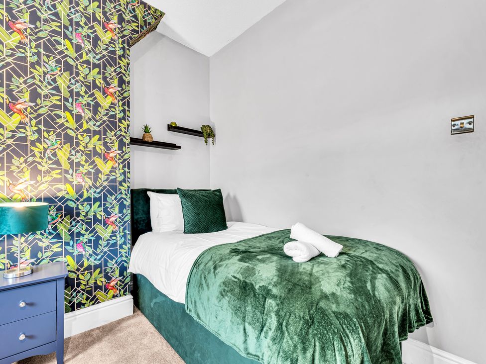 A bedroom with a single bed and a nightstand at Stoke Townhouse in Stoke-on-Trent