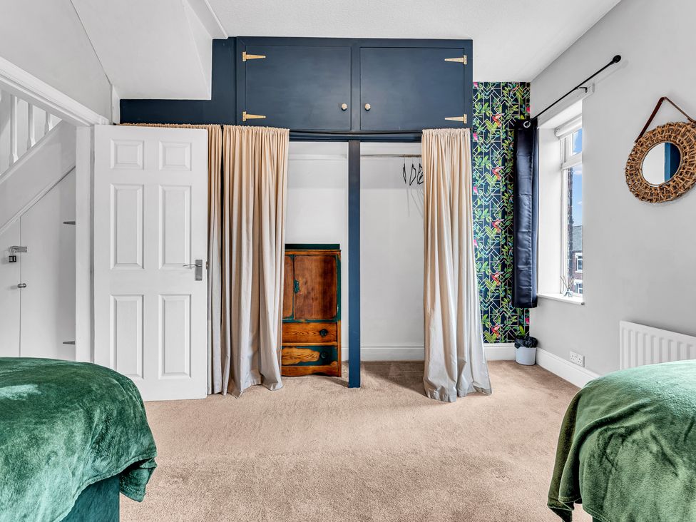 A bedroom with a wardrobe and a mirror at Stoke Townhouse in Stoke-on-Trent