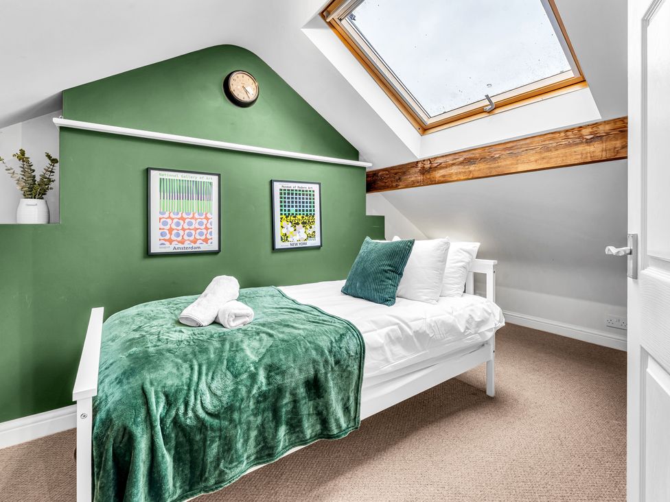 A bedroom with a bed and wall art at Stoke Townhouse in Stoke-on-Trent