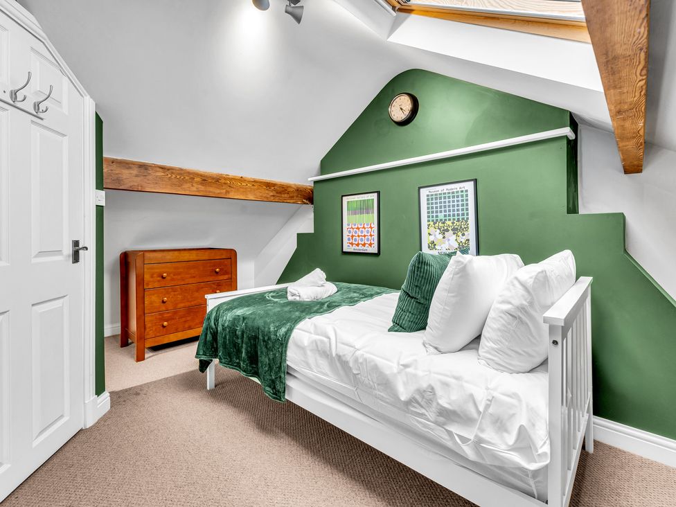 A bedroom with a bed and chest of drawers at Stoke Townhouse in Stoke-on-Trent