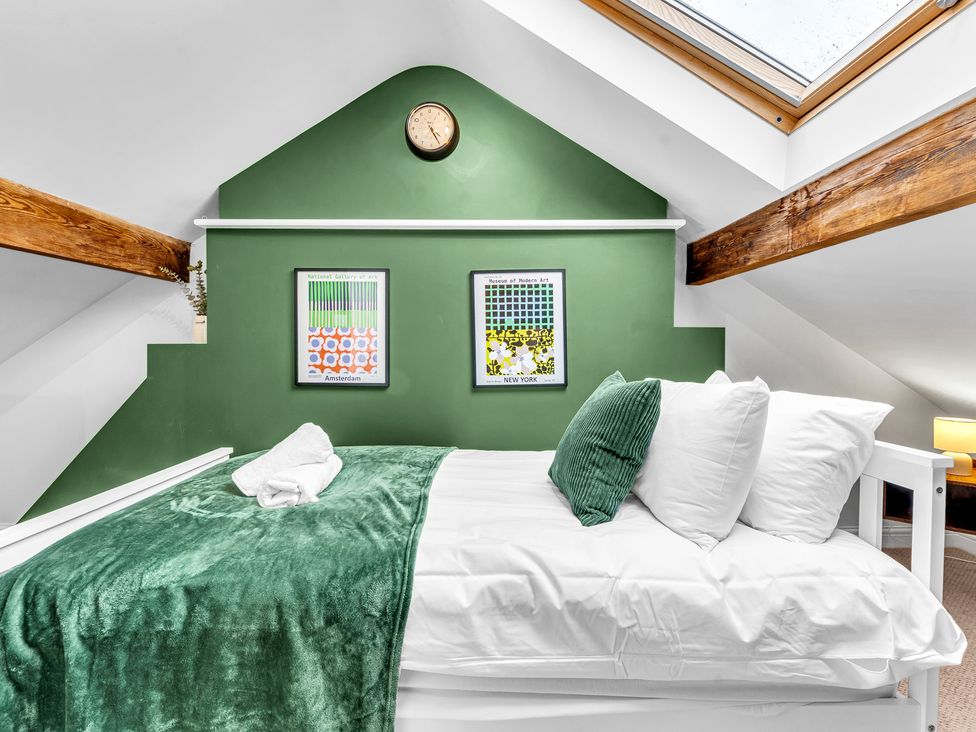 A bedroom with a bed and wall art at Stoke Townhouse in Stoke-on-Trent