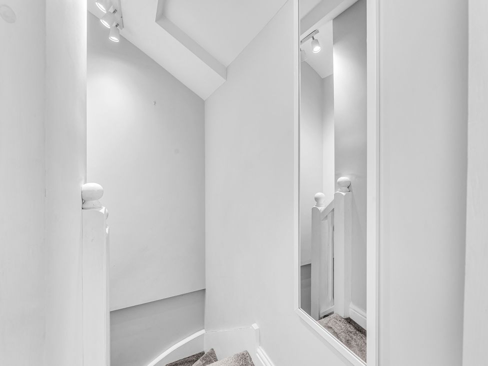 A staircase with a mirror in the hallway at Stoke Townhouse in Stoke-on-Trent