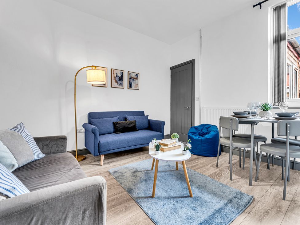 A living room featuring a sofa, dining table and a lamp at Victoria House, Stoke on Trent