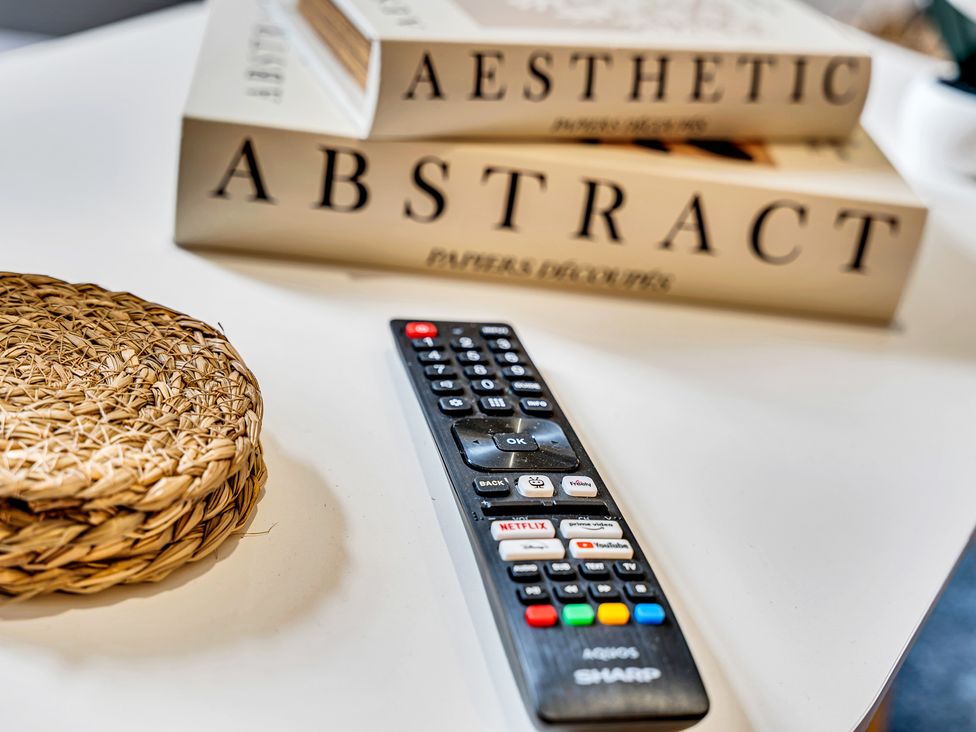 A remote control next to books and a wicker coaster at Victoria House, Stoke on Trent