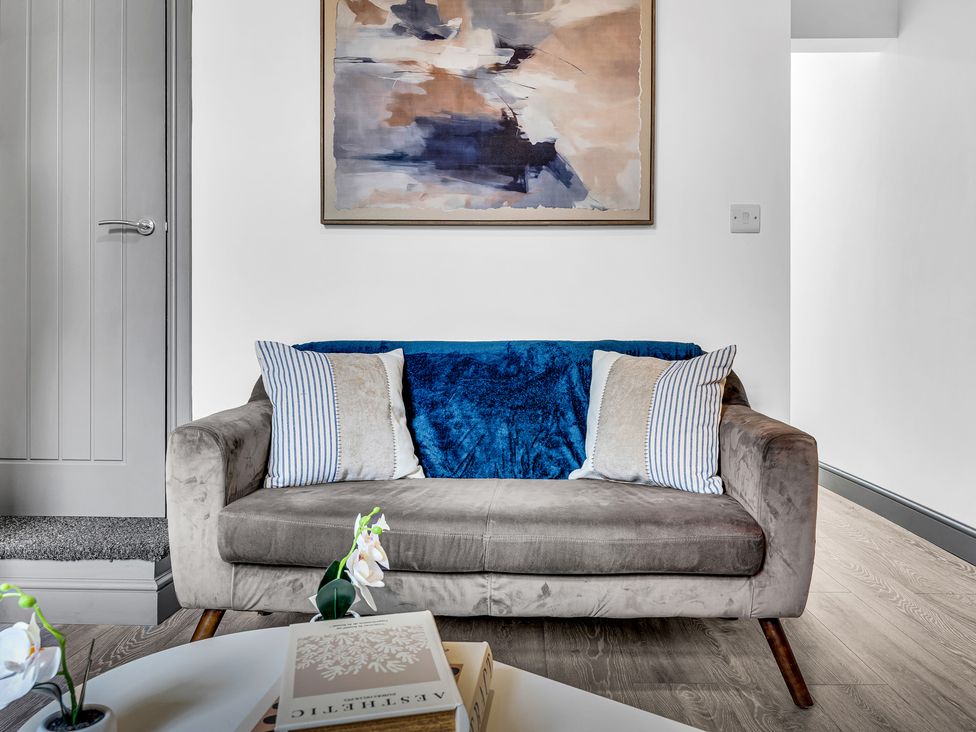 A living room with a sofa and artwork on the wall at Victoria House, Stoke on Trent