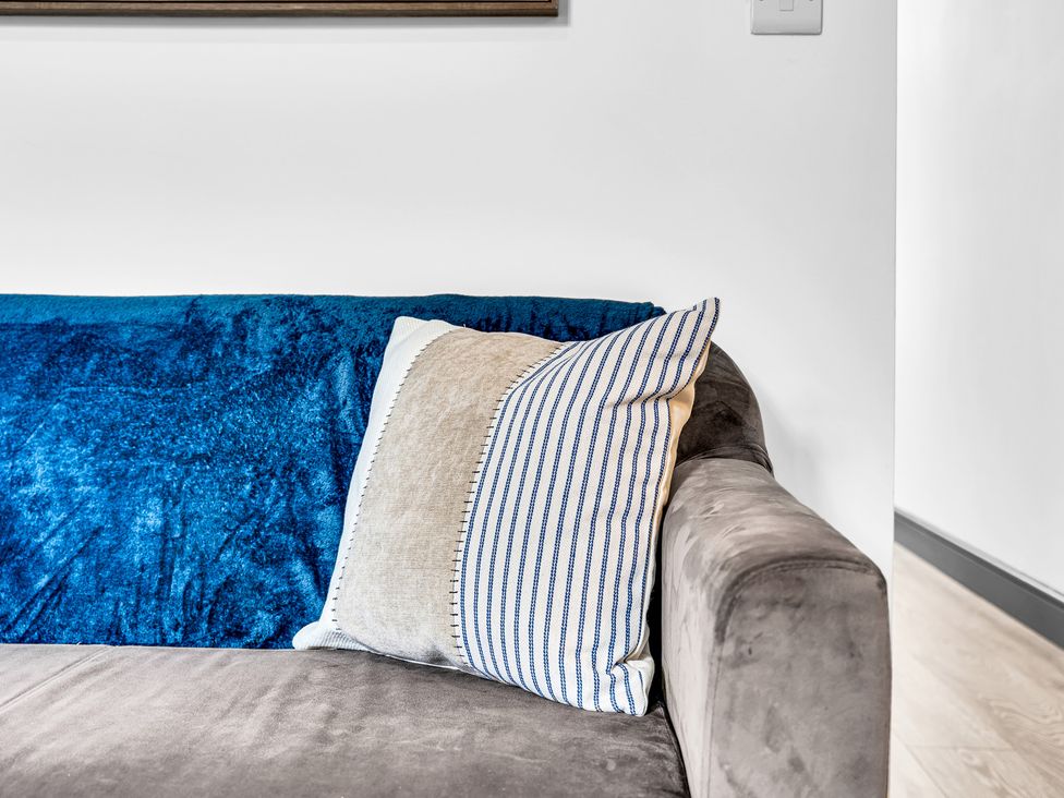 A couch with pillows and a blanket in Victoria House, Stoke on Trent