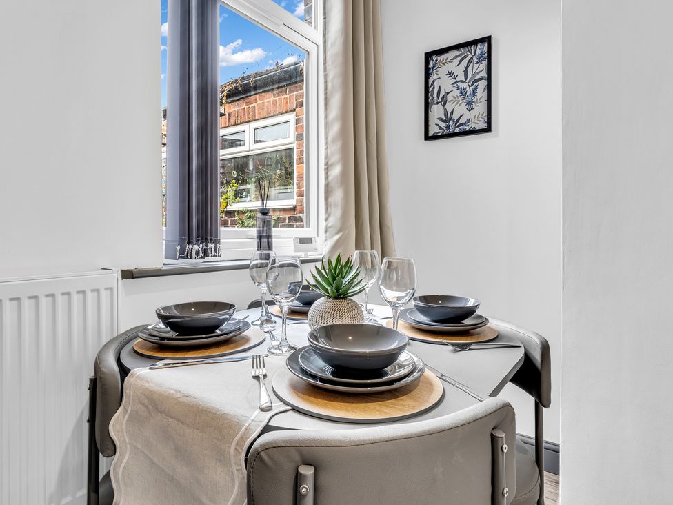 A dining table set with plates and glasses at Victoria House, Stoke on Trent