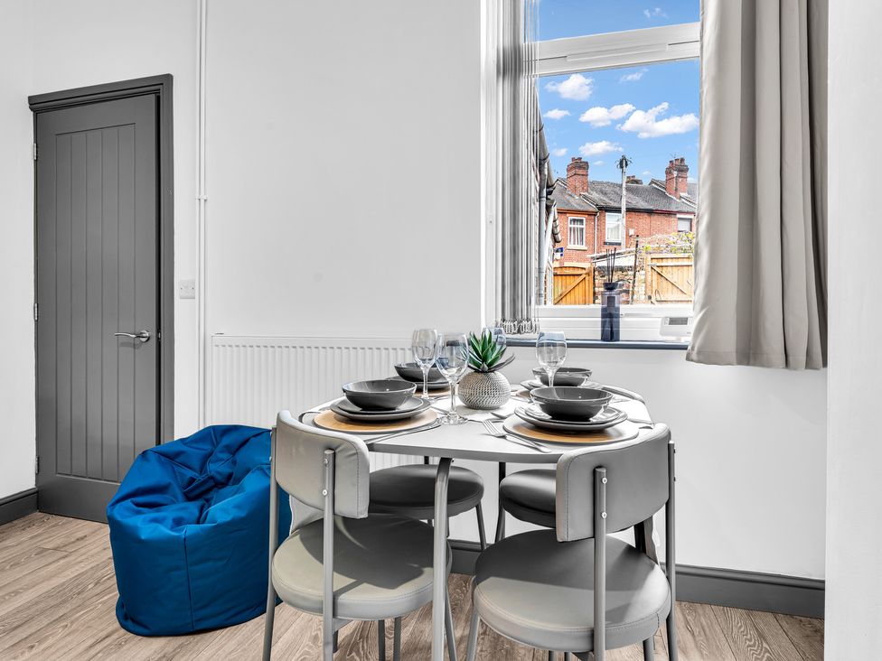 A dining room with a table set near a window at Victoria House, Stoke on Trent