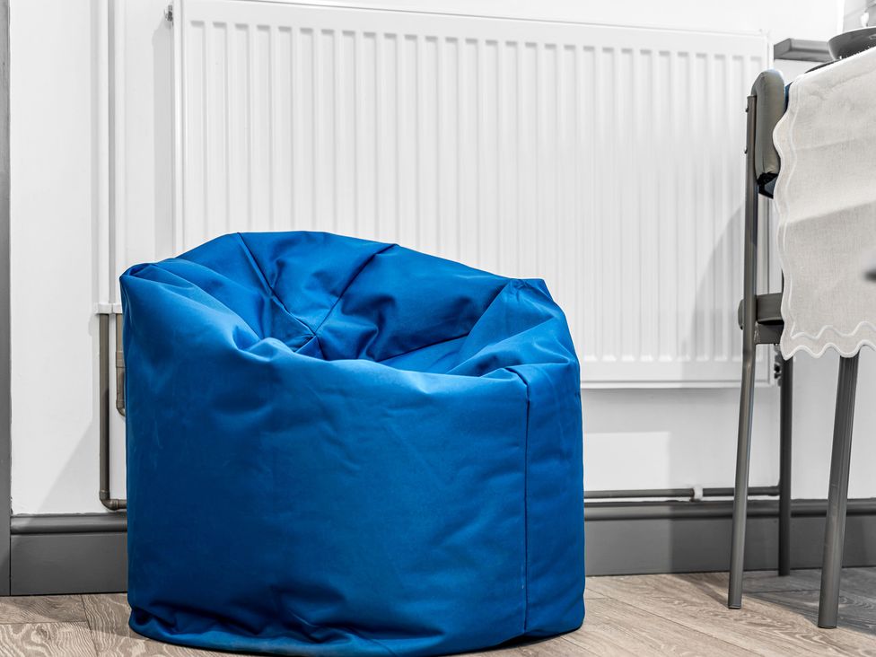 A blue bean bag near a radiator in a living room at Victoria House, Stoke on Trent