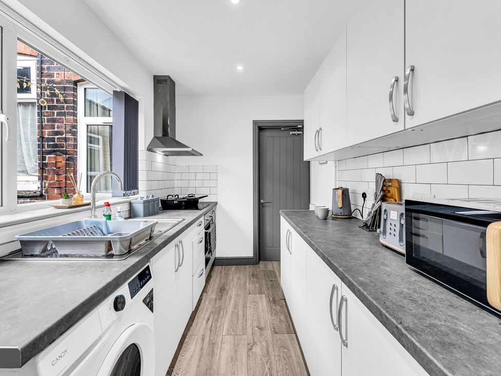 A kitchen with appliances and a sink at Victoria House, Stoke on Trent