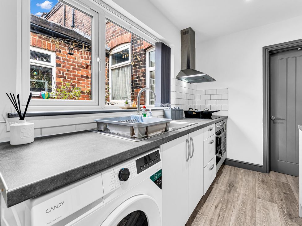 A kitchen with a washing machine and sink at Victoria House, Stoke on Trent