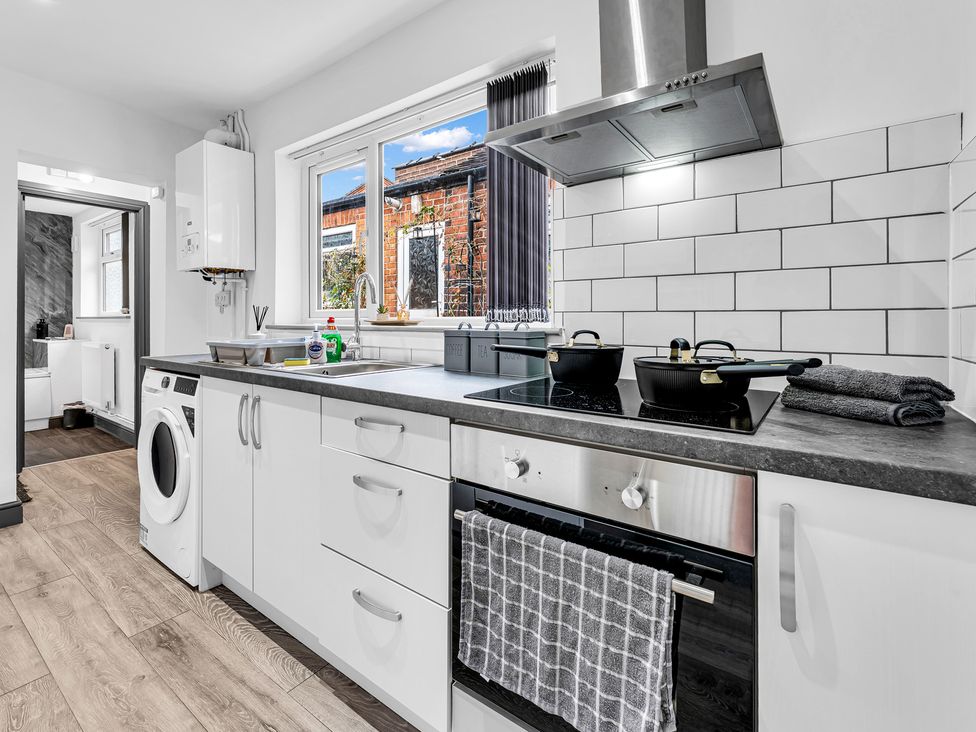 A kitchen with a sink, oven, and washing machine at Victoria House, Stoke on Trent