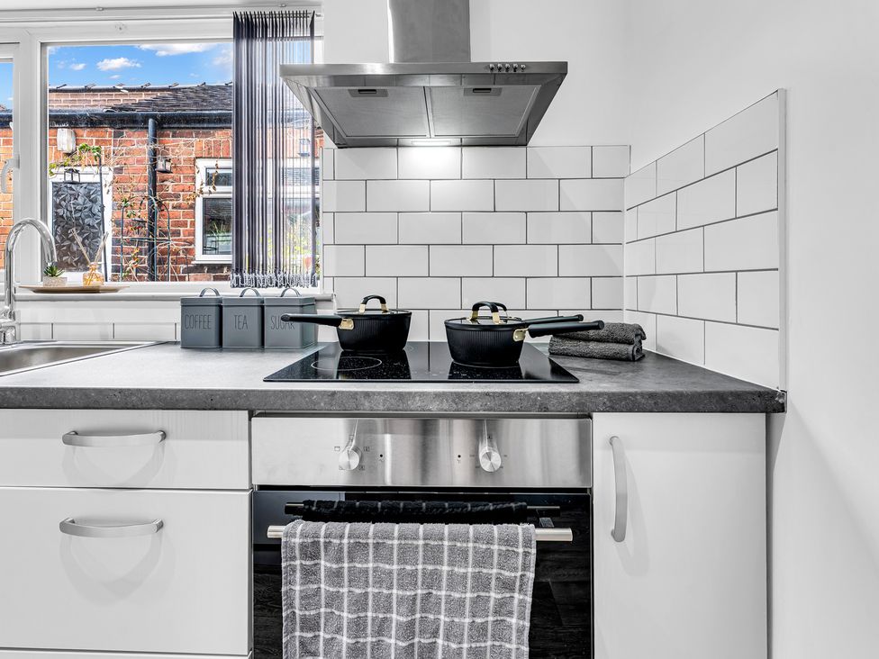 A kitchen with a stove and frying pan at Victoria House, Stoke on Trent