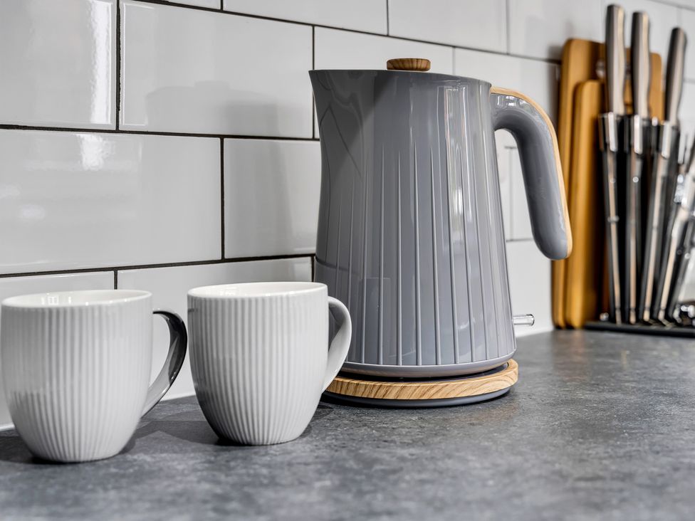A kitchen with an electric kettle and two mugs at Victoria House, Stoke on Trent