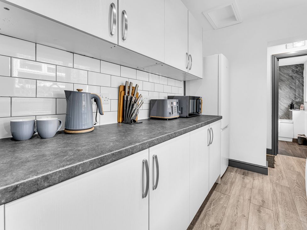 A kitchen with kettle, cups, microwave and toaster at Victoria House, Stoke on Trent