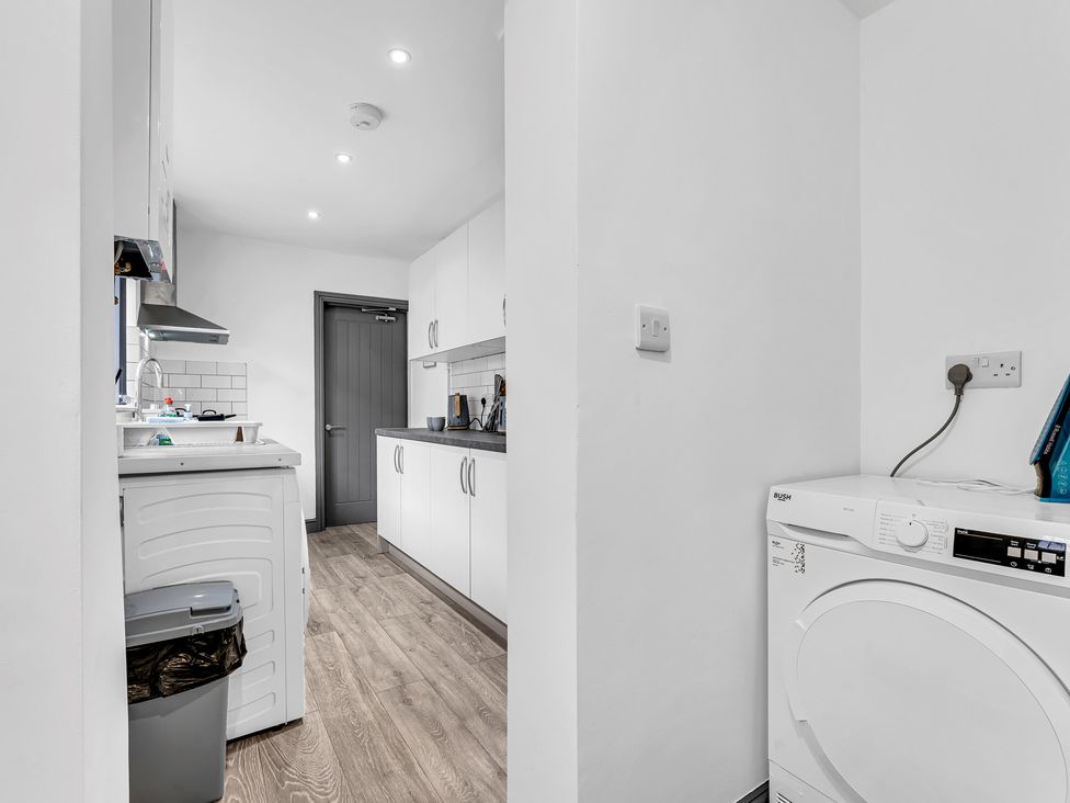 A kitchen with a washing machine and cabinets at Victoria House, Stoke on Trent