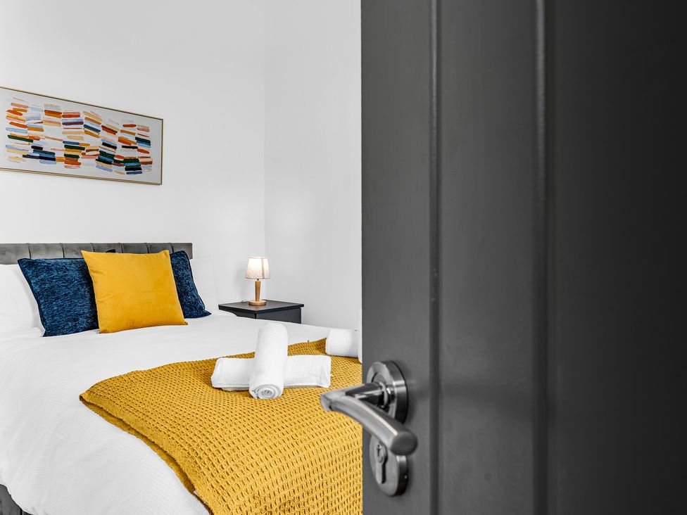 A bedroom with a bed and nightstand at Victoria House, Stoke on Trent