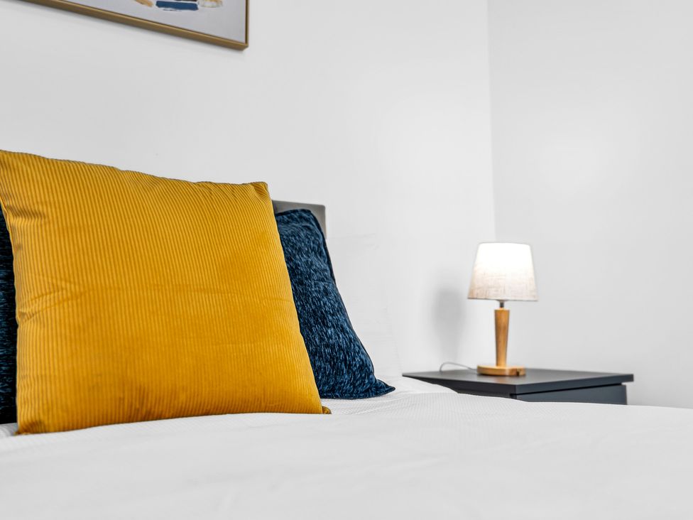 A bedroom with pillows and a lamp at Victoria House, Stoke on Trent