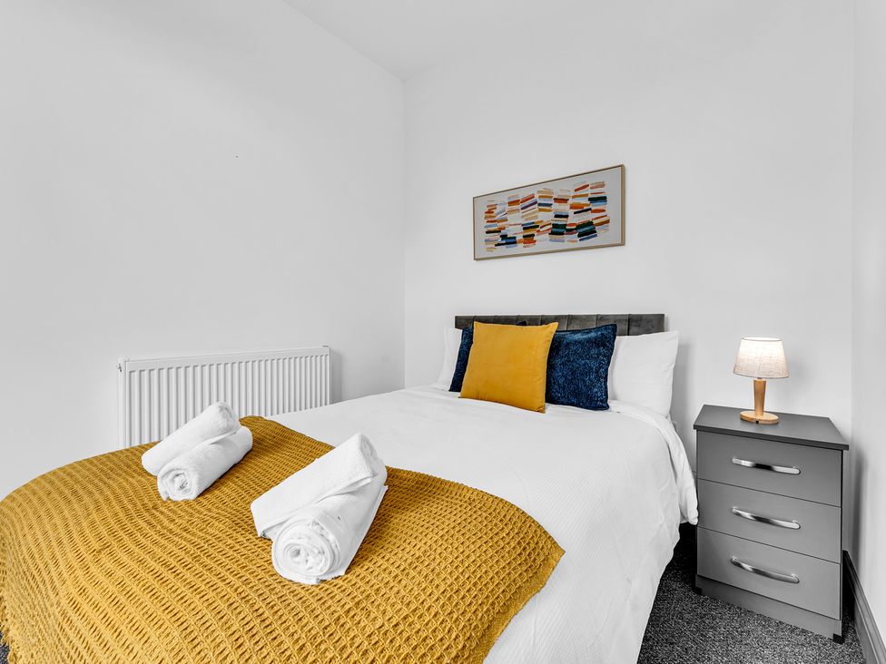 A bedroom with a bed and bedside table at Victoria House, Stoke on Trent