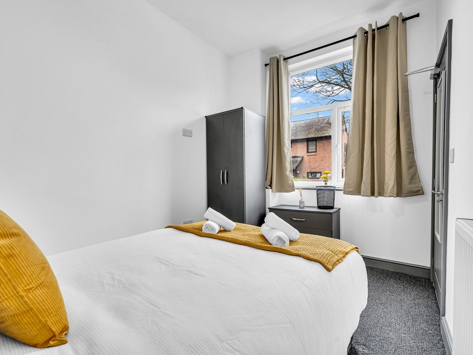 A bedroom with a bed and wardrobe at Victoria House, Stoke on Trent